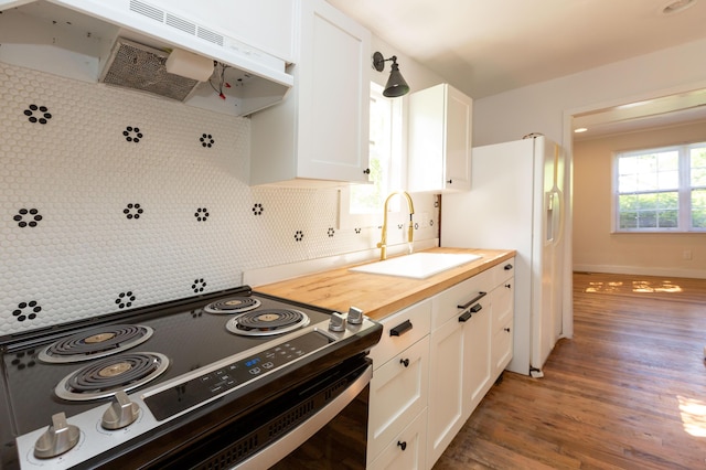 1468 Dewitt St, Augusta, GA 30901 - kitchen with stainless steel range with electric stovetop, extractor fan, wooden counters, decorative backsplash, and white cabinetry
