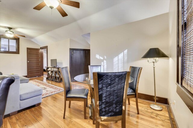 dining space with light wood-type flooring, vaulted ceiling, and ceiling fan