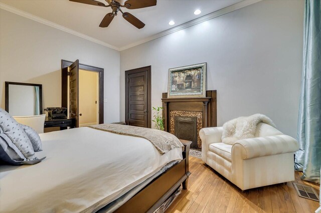 bedroom featuring light hardwood / wood-style flooring, ceiling fan, and crown molding