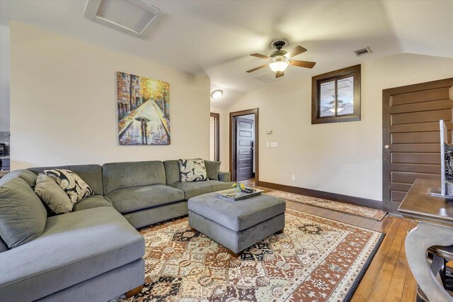 living room with hardwood / wood-style floors, vaulted ceiling, and ceiling fan