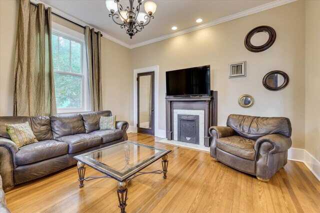 living room featuring light hardwood / wood-style flooring, crown molding, and a chandelier