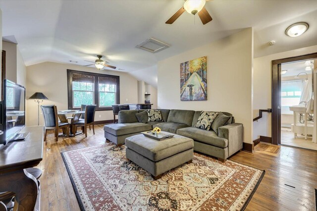 living room with ceiling fan, wood-type flooring, and lofted ceiling