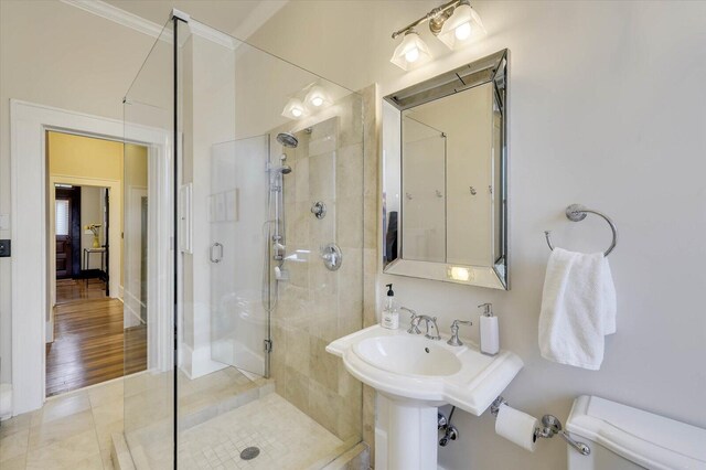 bathroom with tile patterned floors, toilet, walk in shower, and ornamental molding