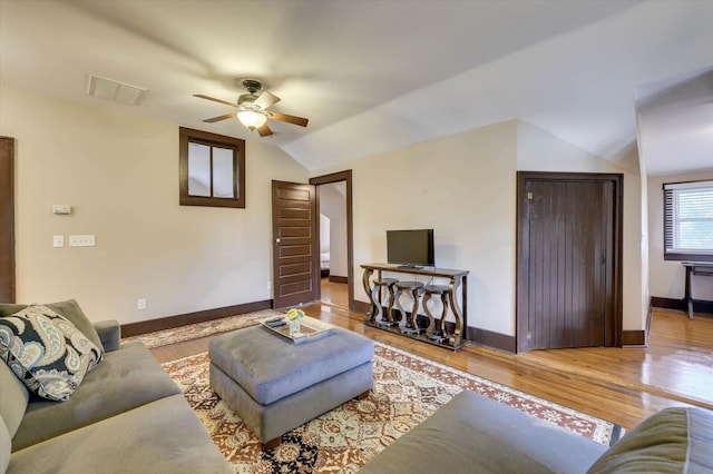 living room with ceiling fan, vaulted ceiling, and hardwood / wood-style flooring