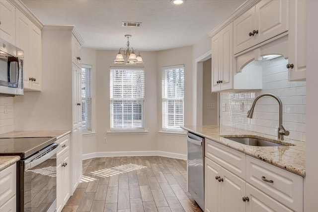 kitchen featuring sink, stainless steel appliances, white cabinets, light wood-type flooring, and a notable chandelier