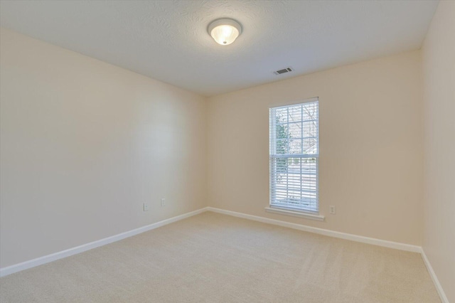 carpeted empty room with a textured ceiling