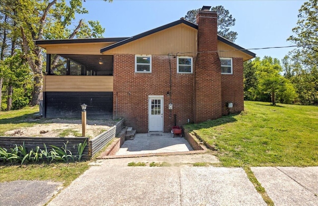 exterior space featuring a yard, brick siding, and a chimney