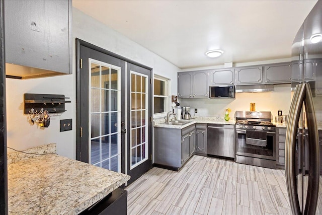 kitchen with french doors, gray cabinets, a sink, and stainless steel appliances