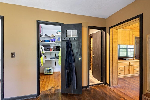 hall featuring baseboards and wood finished floors