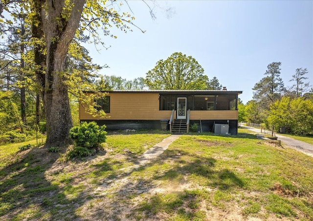 view of front of home with a sunroom and a front yard