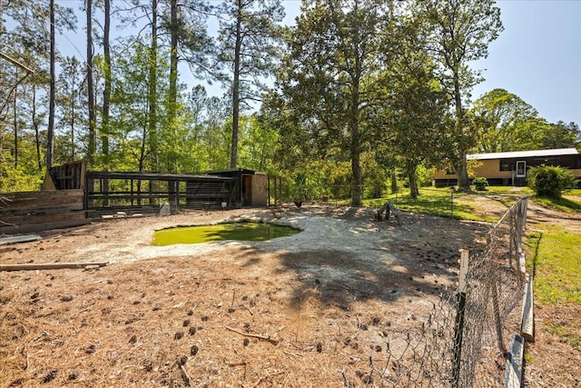 view of yard with fence and an outdoor structure
