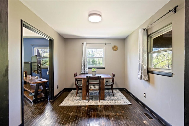 dining area featuring baseboards, dark wood-style floors, and a wealth of natural light