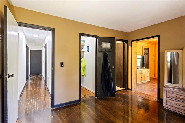 hallway featuring dark wood-style floors and baseboards