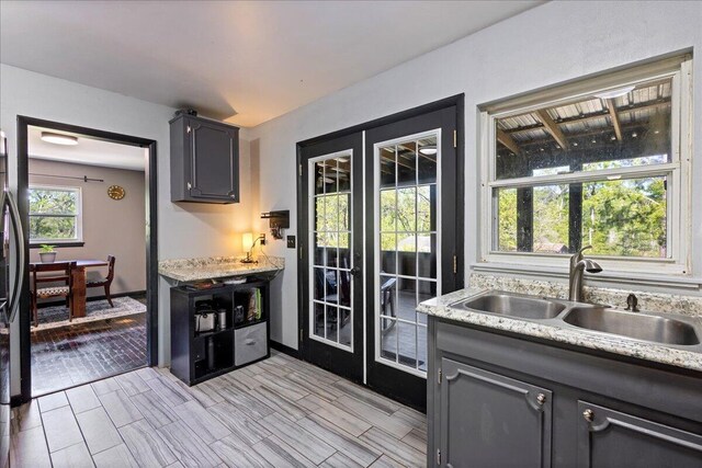 doorway to outside with a sink, french doors, and wood finish floors