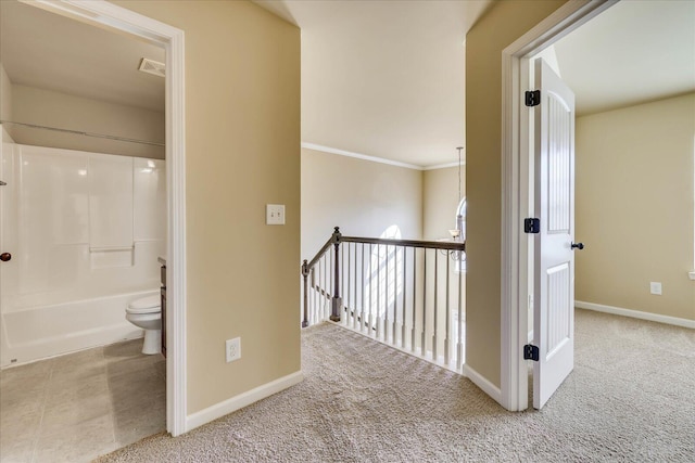 hallway featuring crown molding and light carpet