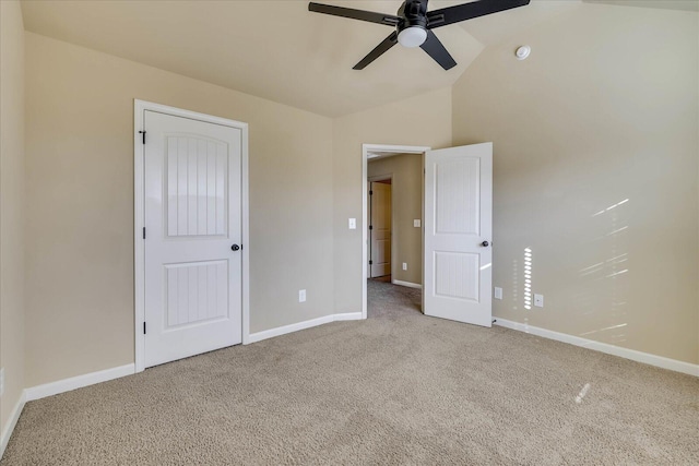 unfurnished bedroom featuring carpet flooring, vaulted ceiling, and ceiling fan