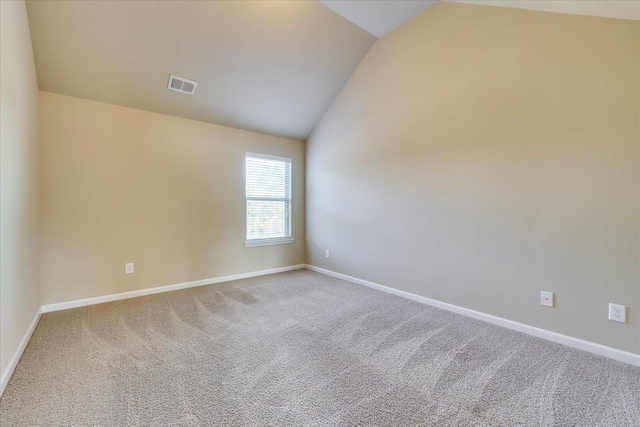 unfurnished room featuring carpet and lofted ceiling