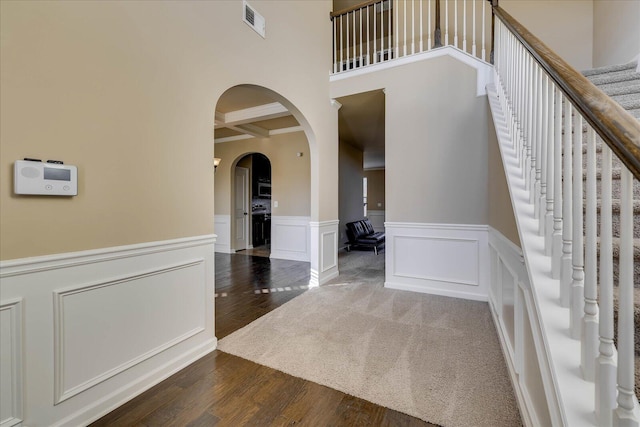 foyer entrance with beamed ceiling, dark hardwood / wood-style floors, and coffered ceiling