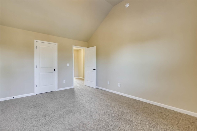 carpeted empty room featuring high vaulted ceiling