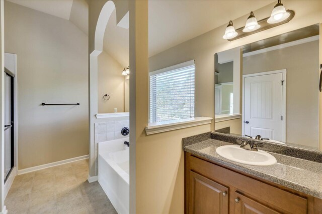 bathroom with vanity, independent shower and bath, and vaulted ceiling