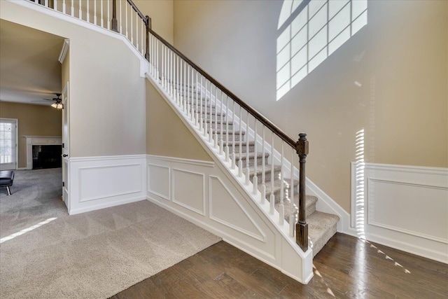 stairway featuring ceiling fan and wood-type flooring