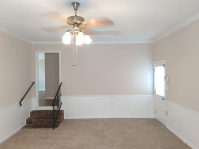 carpeted spare room with ceiling fan and crown molding