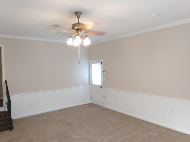 unfurnished room with ceiling fan, light colored carpet, and ornamental molding