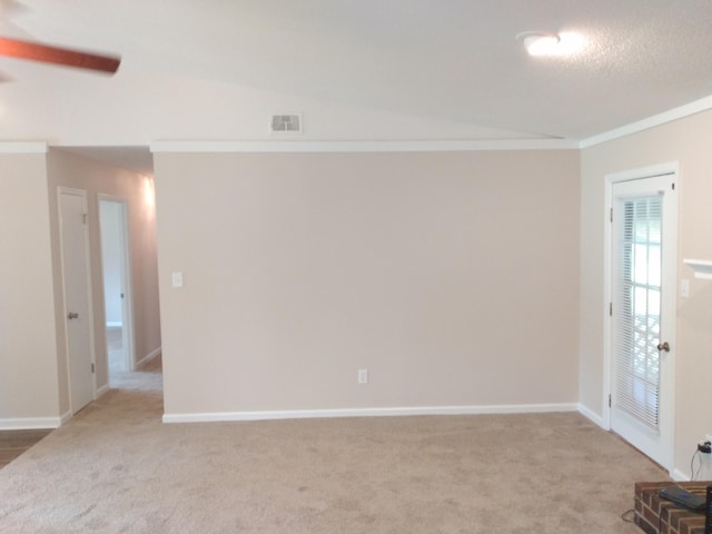 spare room with a textured ceiling, carpet floors, and ornamental molding