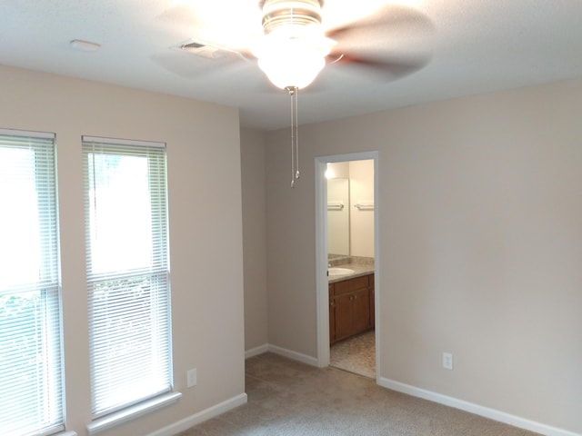 unfurnished room with light carpet, ceiling fan, and sink