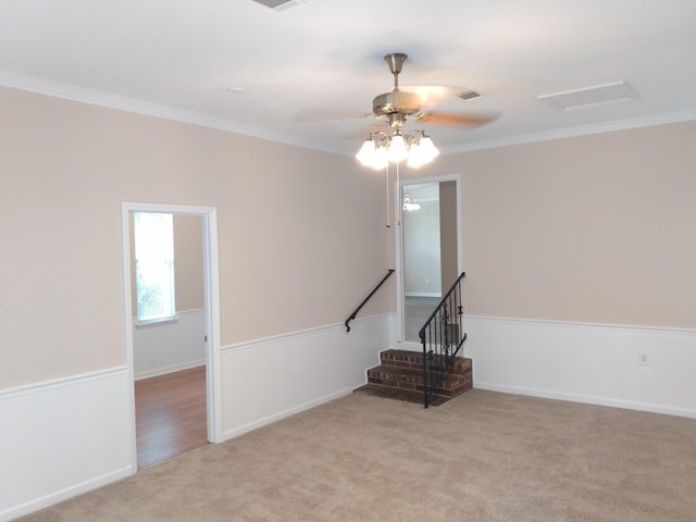 carpeted spare room with ceiling fan and ornamental molding