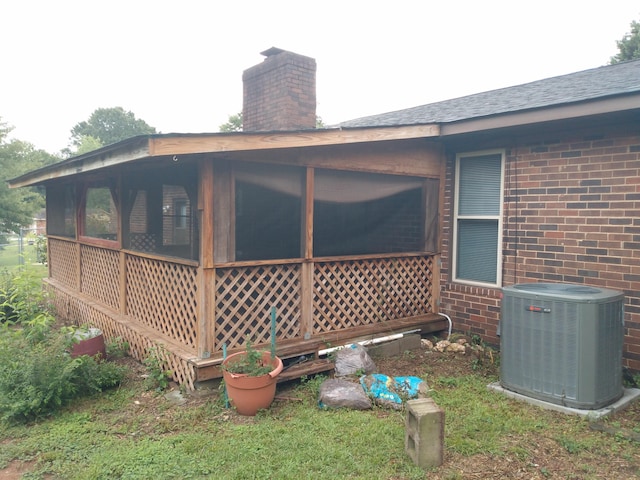 view of side of home featuring central AC and a sunroom