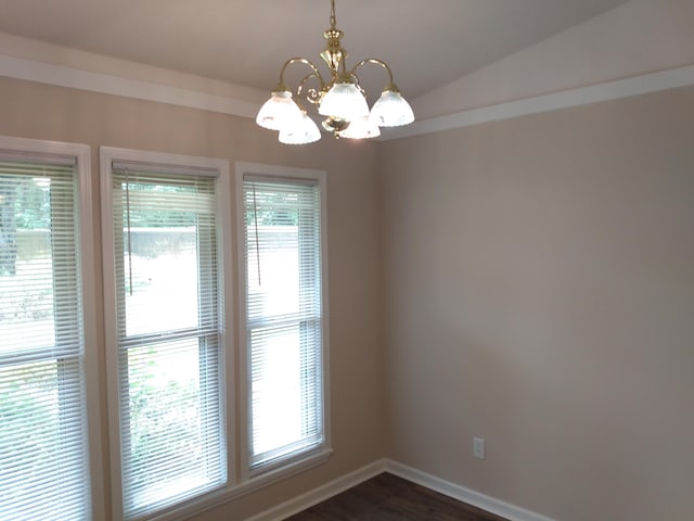 spare room featuring a chandelier, dark hardwood / wood-style floors, and vaulted ceiling