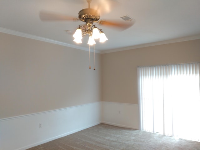 carpeted empty room with ceiling fan and crown molding