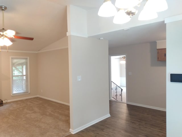 empty room with ceiling fan with notable chandelier, crown molding, and lofted ceiling