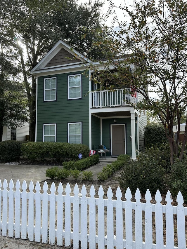 view of front of property featuring a fenced front yard and a balcony