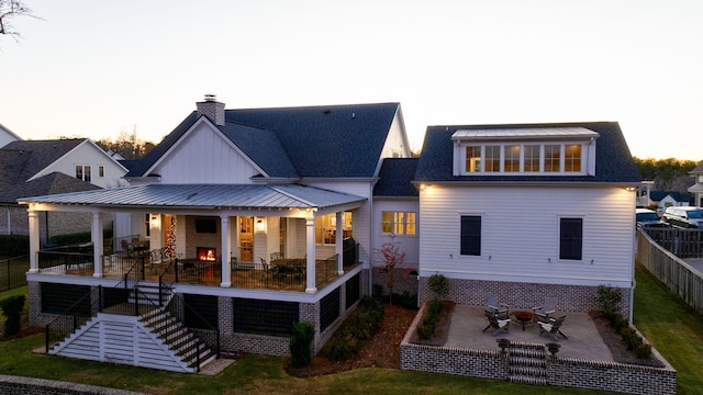 back house at dusk with a fire pit and a patio area