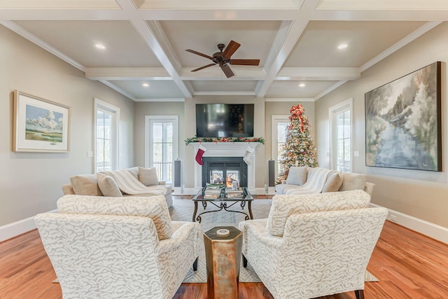 living room with hardwood / wood-style floors, ceiling fan, crown molding, and coffered ceiling