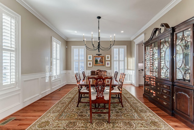 dining area featuring a chandelier, hardwood / wood-style floors, and crown molding