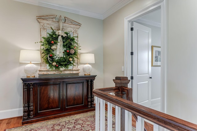 hall with light wood-type flooring and ornamental molding