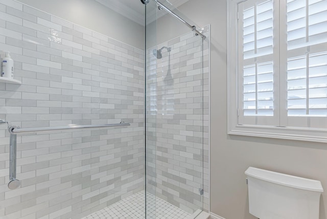 bathroom featuring crown molding, a shower with door, and toilet