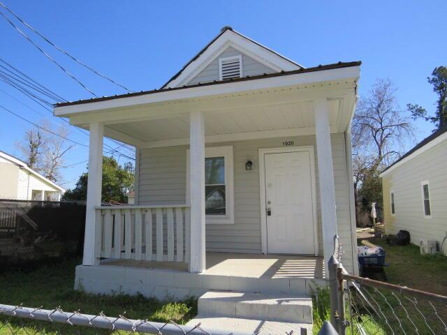 view of front of property featuring fence and a porch