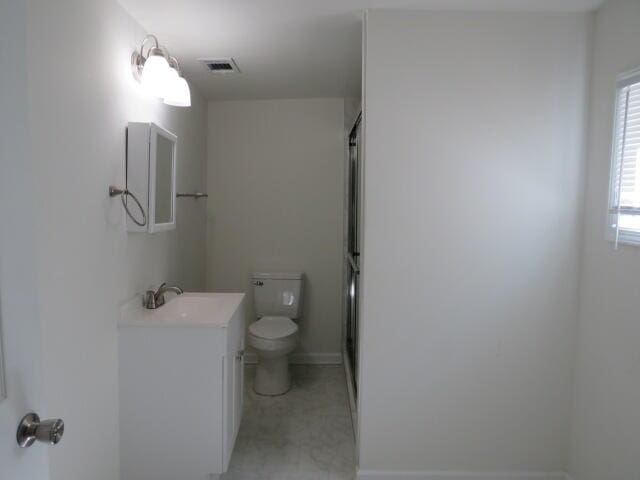 full bathroom featuring visible vents, a shower with shower door, vanity, and toilet