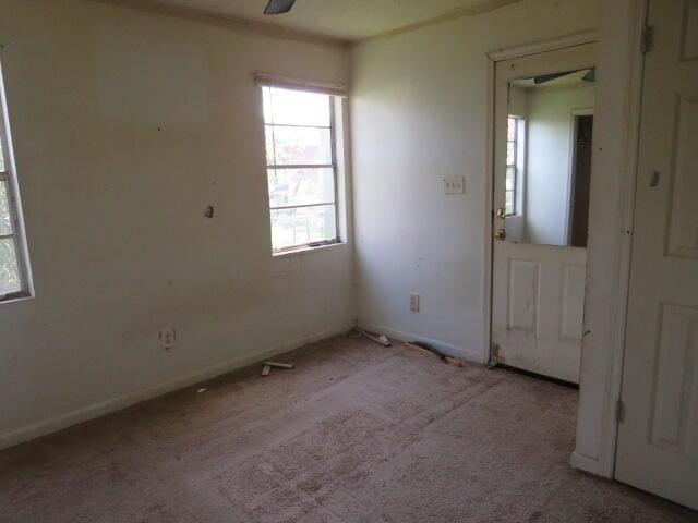 empty room with carpet floors, ceiling fan, and baseboards