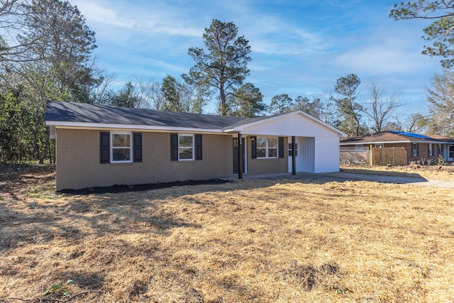 ranch-style home featuring brick siding, a front yard, and fence