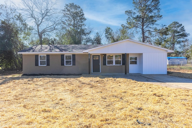 single story home with a front lawn, concrete driveway, and brick siding