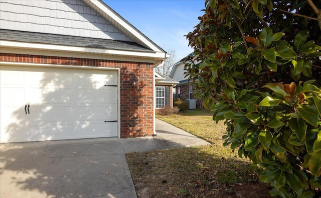 view of side of property featuring a yard, a garage, and cooling unit