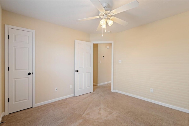 unfurnished bedroom featuring light carpet and ceiling fan