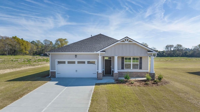 craftsman inspired home with an attached garage, concrete driveway, a front lawn, and a shingled roof