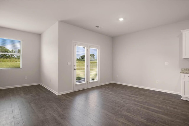 unfurnished living room with dark wood-type flooring, recessed lighting, visible vents, and baseboards