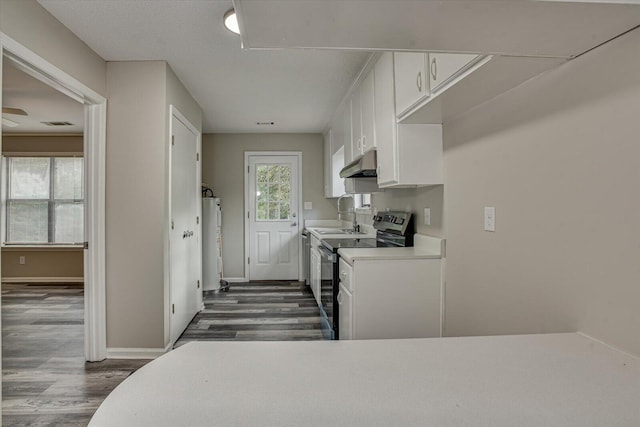 kitchen featuring electric stove, a textured ceiling, water heater, dark hardwood / wood-style flooring, and white cabinetry